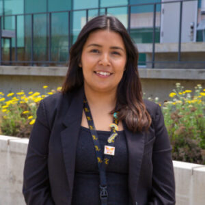 Alejandra Garcia, Dreamer Center Coordinator, in front of campus building. 