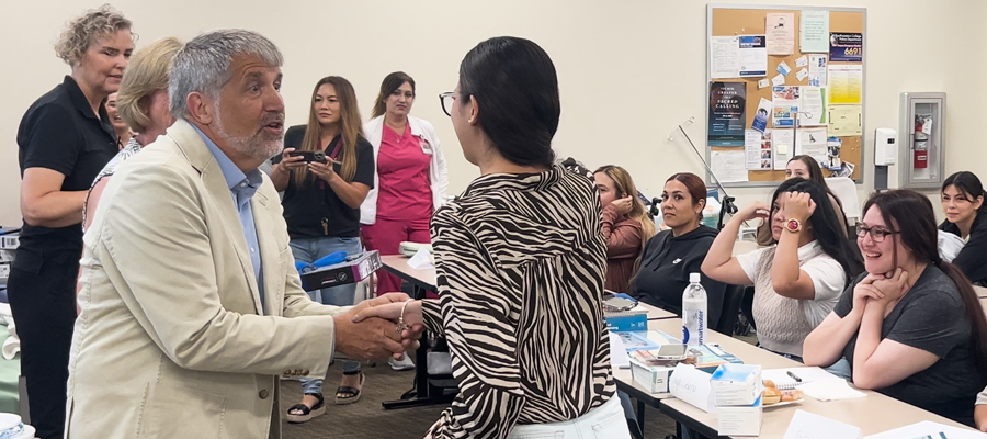 Marc Lookabaugh, founder of the Guy and Olive Lookabaugh Foundation, shaking hands with Southwestern College Vocational Nurse student. 